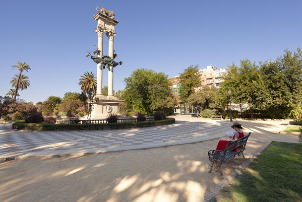 A woman reads in front of Monument to Christopher Columbus, Jardines de Murillo (Murillo Gardens),  Seville, province of Seville, Andalusia, Spain
