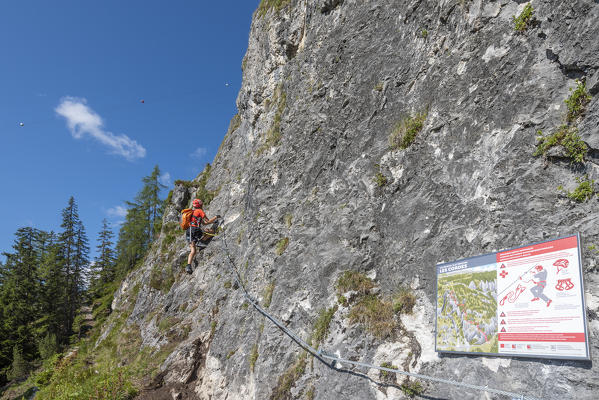 Alta Badia, La Villa, Dolomites, province of Bolzano, South Tyrol, Italy, Europe. A girl climbs on the via ferrata 