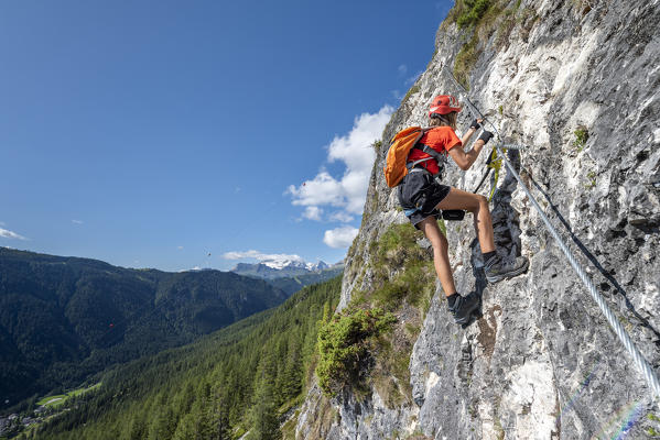 Alta Badia, La Villa, Dolomites, province of Bolzano, South Tyrol, Italy, Europe. A girl climbs on the via ferrata 