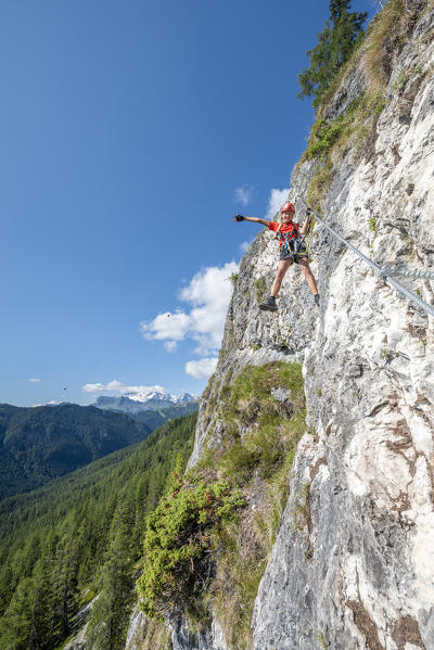 Alta Badia, La Villa, Dolomites, province of Bolzano, South Tyrol, Italy, Europe. A girl climbs on the via ferrata 