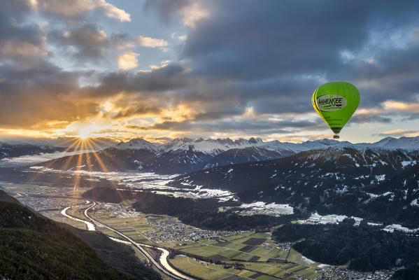 Seefeld, Tyrol, Austria, Europe. Crossing the alps in a hot air balloon. The hot air balloon above the Inn Valley at sunrise