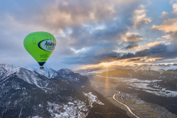 Seefeld, Tyrol, Austria, Europe. Crossing the alps in a hot air balloon. The hot air balloon above the Inn Valley at sunrise