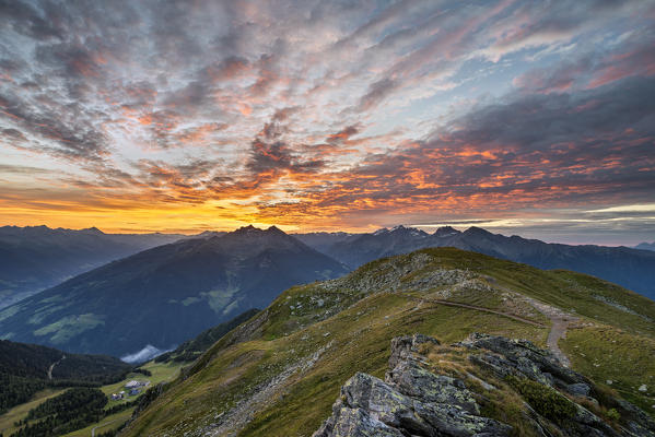 Sand in Taufers / Campo Tures, Bolzano province, South Tyrol, Italy. Sunrise at the summit of Speikboden. In the background the peaks of the mountain groups Hohe Tauern, Durreck and Rieserferner