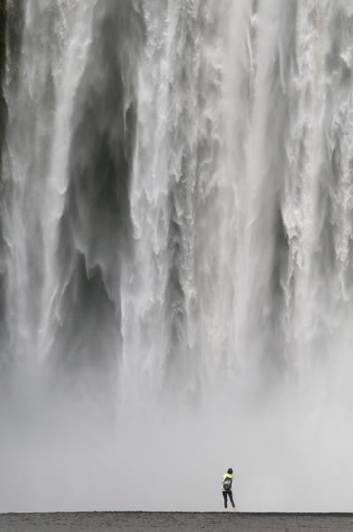 Southern Iceland. Tourists under the Skogafoss waterfall.