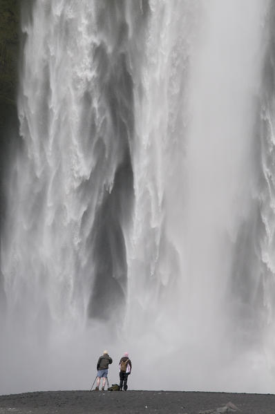 Southern Iceland. Tourists under the Skogafoss waterfall.