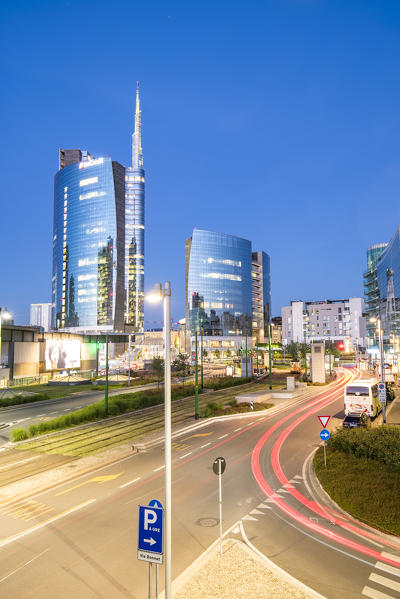 Milan, Lombardy, Italy. Skyscrapers of Porta Nuova business district at dusk with passing cars lights.