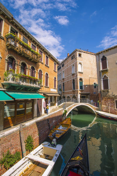 Venice, Veneto, Italy. Gondola sailing through a street canal.