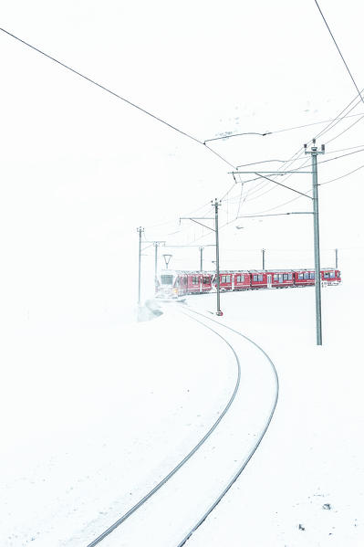 Red Bernina train in snow of Bernina pass. Switzerland, Europe