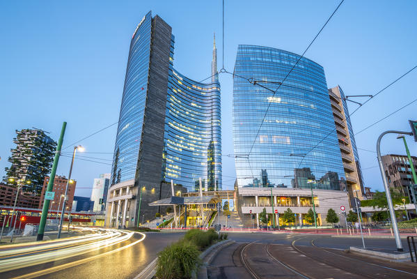 Milan, Lombardy, Italy. Skyscrapers of Porta Nuova business district at dusk with passing cars lights.