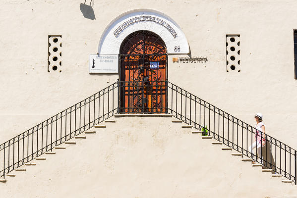 Colonial Zone (Ciudad Colonial), Santo Domingo, Dominican Republic. Woman on the stairs of a typical colonial building (MR).