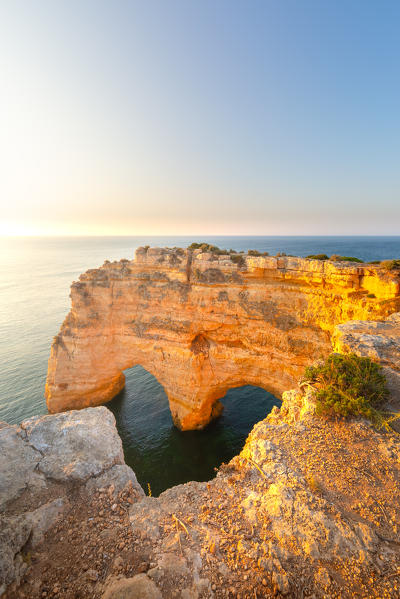 Heart shaped rock near Praia da Marinha, Algarve, Portugal. View at sunrise