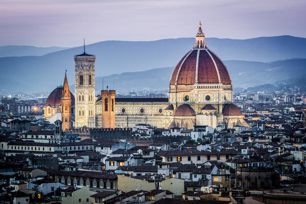 Florence, Tuscany, Italy. cityscape and Cathedral and Brunelleschi Dome, Giotto Tower. Sunset, lights on.