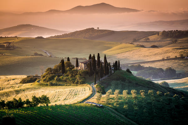 Val d'Orcia, Tuscany, Italy. A lonely farmhouse with cypress and olive trees, rolling hills.