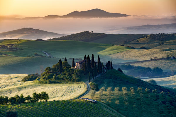 Val d'Orcia, Tuscany, Italy. A lonely farmhouse with cypress and olive trees, rolling hills.