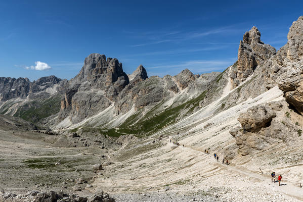A group of hikers in the Vajolet Valley with the peaks of the Catinaccio group, Dolomites, Trentino Alto Adige, Italy