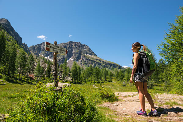 Europe, Italy, Trentino Alto Adige. hiker looks signage CAI / SAT 628 along the trial  from the Cimon di Bocche, Dolomites