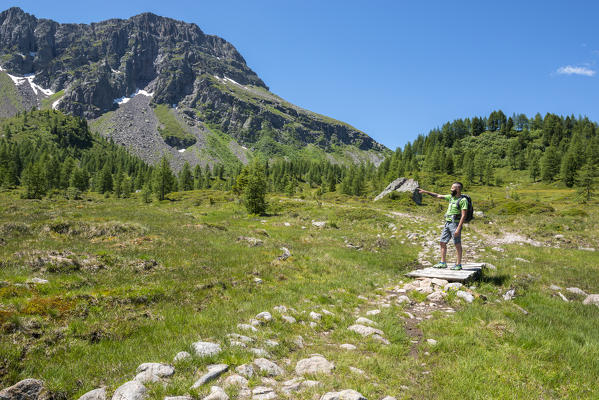 Italy, Trentino Alto Adige, San Pellegrino pass, Hiker on his way to the Cimon di Bocche peack along the trial n.628 from the San Pellegrino pass.