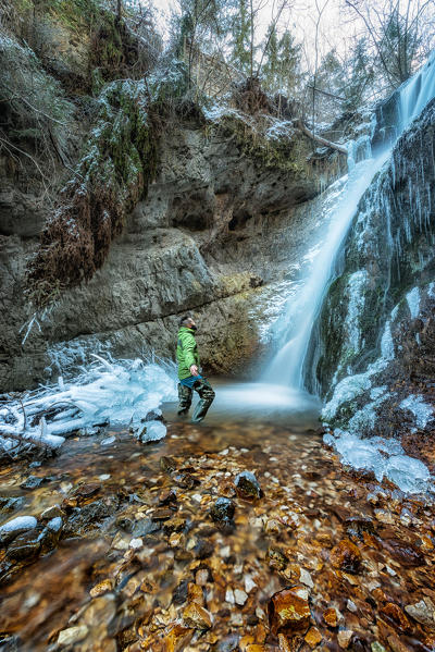 hiker admiring Koflertal waterfall, Non valley, Trentino Alto Adige, Italy