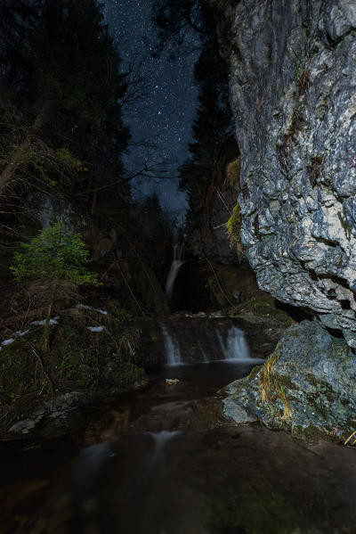 Starry night over Koflertal waterfall in winter, Non Valley, Trentino Alto Adige, Italy