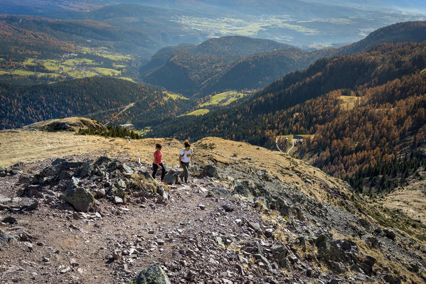 Italy, Trentino Alto Adige, Non valley, two women hikers climb to the summit of Luco Mount in autumn day.
