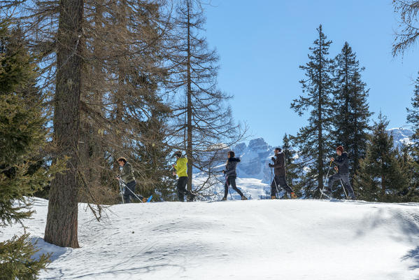 Hikers with snowshoe adventure on the snow towards nambino lake, natural park Adamello Brenta, Madonna di Campiglio, Trentino Alto Adige, Italy, Europe.