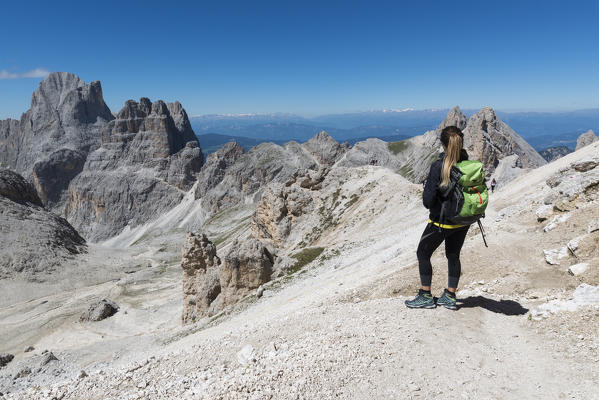 Hiker admires the Panoramic view of Antermoia valley seen from Antermoia pass, dolomites, Fassa valley, Trentino South Tyrol, Italy