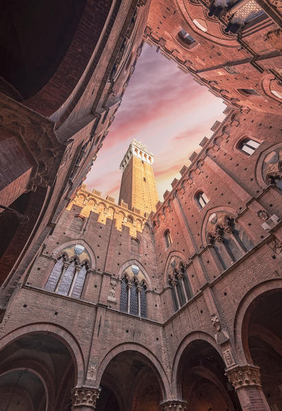 Siena, Tuscany, Italy, Europe. Classic bottom view of Palazzo Pubblico with Del Mangia's Tower at dawn.