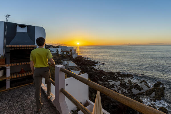 Spain, Canary Islands, Tenerife, Boca Cangrejo, a man admires the sunrise over the ocean (MR)
