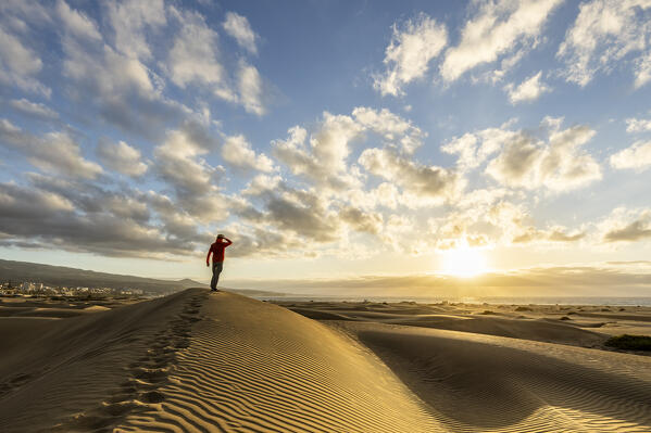 Spain, Canary Islands, Gran Canaria,a man admires the sunrise from the dunes of Maspalomas (MR)