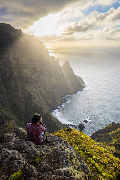 Spain,Canary Islands,Tenerife, hiker photographs cliffs of Anaga Rural Park (MR)