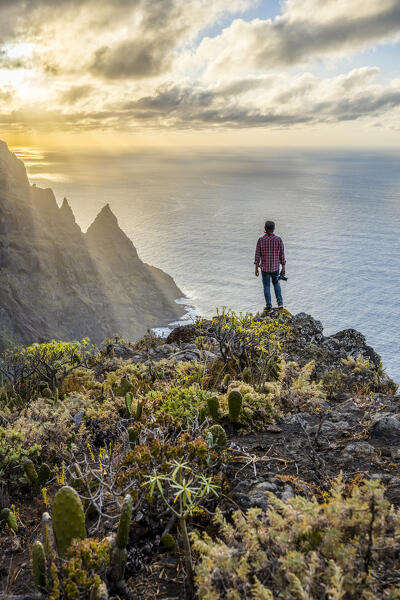 Spain,Canary Islands,Tenerife, hiker admires sunset from cliffs of Anaga Rural Park (MR)