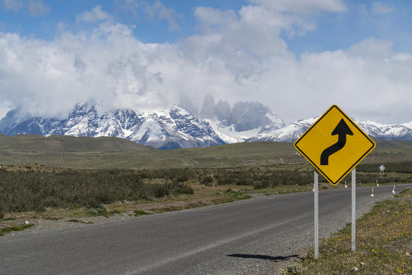 Road sign and Paine Towers in the background in summer. Torres del Paine National Park, Ultima Esperanza province, Magallanes region, Chile.