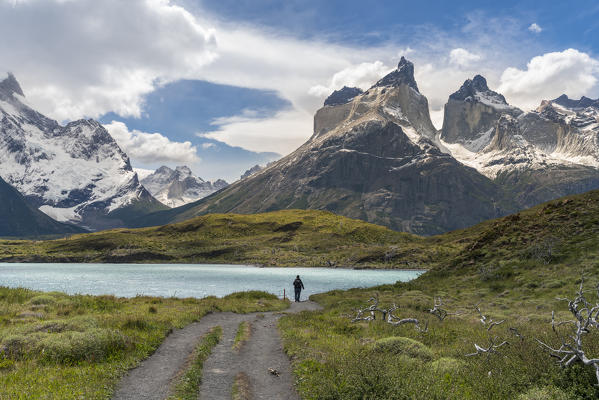 Woman walking on the footpath towards Mirador Cuernos, with Nordenskjold Lake and Paine Horns in the background, in summer. Torres del Paine National Park, Ultima Esperanza province, Magallanes region, Chile.