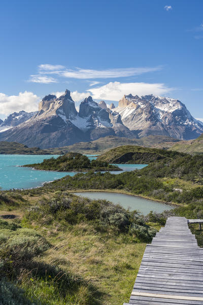 Boardwalk with Lake Pehoé and Paine Horns in the background, on a windy summer day. Torres del Paine National Park, Ultima Esperanza province, Magallanes region, Chile.