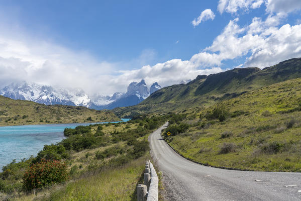 Dirt road and Lake Pehoé and Paine Horns in the background, in summer. Torres del Paine National Park, Ultima Esperanza province, Magallanes region, Chile.