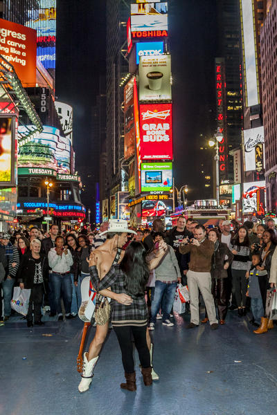 The Naked Cowboy poses for photographs with tourists in Times Square, New York, USA