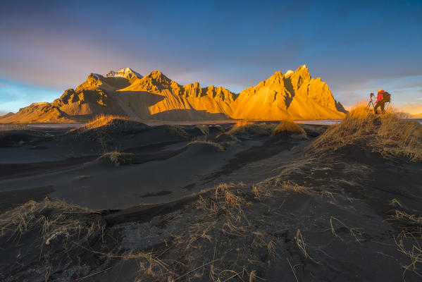 Man photographing the landscape at sunset. Stokksnes, Eastern Iceland, Europe