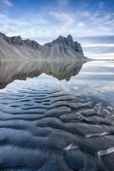 The mountains reflect on the surface of the ocean. Stokksnes, Eastern Iceland, Europe