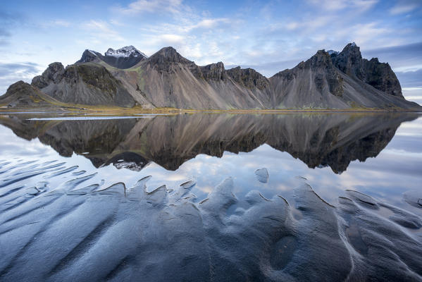 The mountains reflect on the surface of the ocean. Stokksnes, Eastern Iceland, Europe