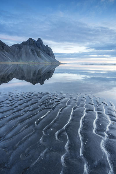 The mountains reflect on the surface of the ocean. Stokksnes, Eastern Iceland, Europe