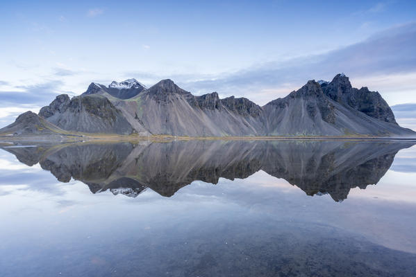 The mountains reflect on the surface of the ocean. Stokksnes, Eastern Iceland, Europe
