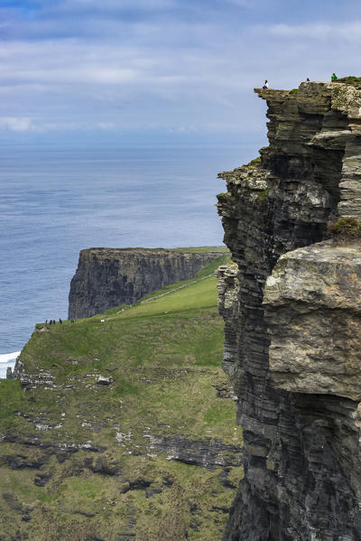 Person on the edge of a cliff at Cliffs of Moher, Liscannor, Munster, Co.Clare, Ireland, Europe.