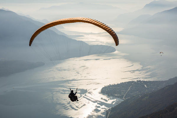 Paragliding over Lake Como and the surroundings mountains. Alto Lario, Como, Lombardy, Italy, Europe.