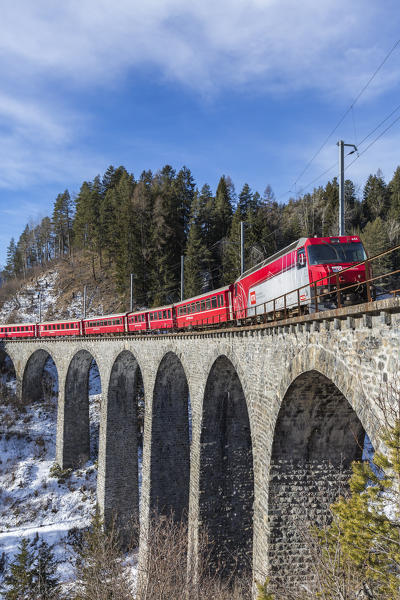 Bernina Express red train  along Schmittentobel Viaduct. Filisur, Graubunden, Switzerland, Europe.