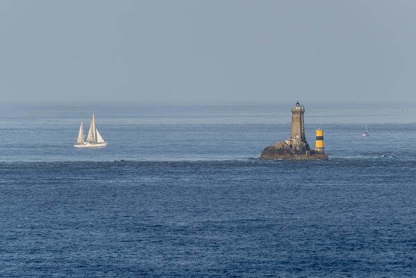 Vieille lighthouse and sail boat from Van point. Cléden-Cap-Sizun, Finistère, Bretagne, France.