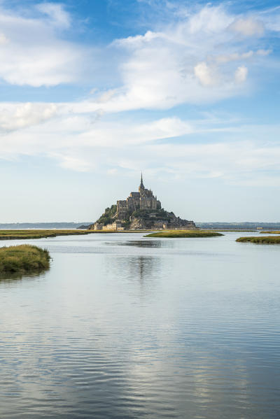 Clouds in the sky and water in the foreground. Mont-Saint-Michel, Normandy, France.