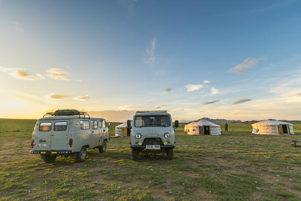 Mongolian nomadic traditional gers and soviet minivans at sunset. Middle Gobi province, Mongolia.