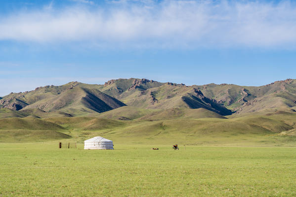 Nomadic ger, motorbike and mountains in the background. Bayandalai district, South Gobi province, Mongolia.