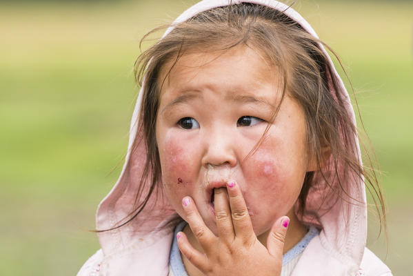 Portrait of a Mongolian Nomadic little girl with hood. North Hangay province, Mongolia.