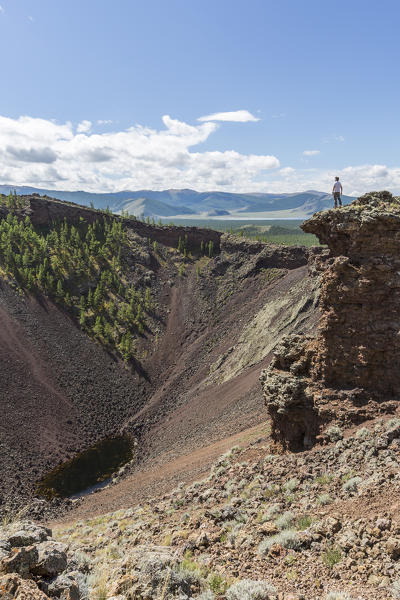 Man gazing at Khorgo volcano crater. Tariat district, North Hangay province, Mongolia.